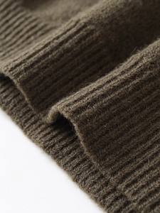 Détail de la texture en maille côtelée vert olive foncé avec des fibres de laine douces