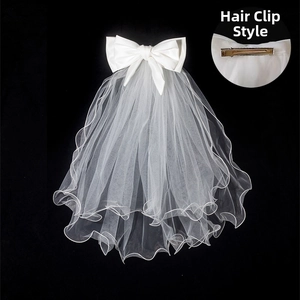 Close-up of short bridal veil with satin bow and hair clip for wedding photos