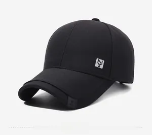 Side view detail of black cotton baseball cap showing silver embroidered logo and texture