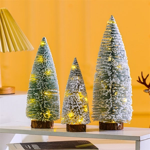 Three mini flocked Christmas trees with warm LED lights on natural wood bases