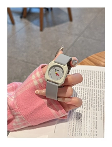 Close-up of a stylish square watch with grey silicone strap on a woman's wrist