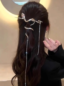 Detail of silver snake hair pin with sparkling tassel hanging on a low ponytail