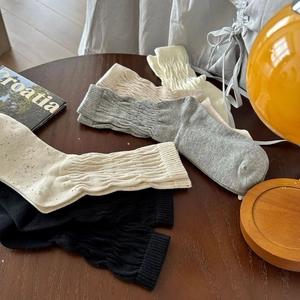 Dettaglio di calze in maglia di cotone multicolore con trama a trecce e finitura a coste