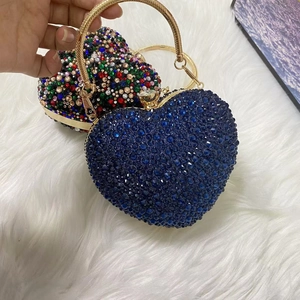 Close-up of heart-shaped evening bags with blue and colorful rhinestones and gold handles