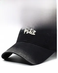 Detail of vintage washed black baseball cap with 3D FBQE embroidery and distressed finish