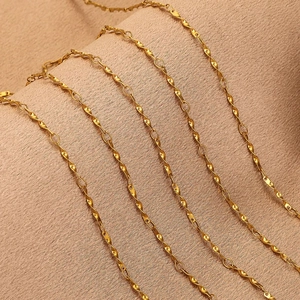 Twisted Cuban chain 18K gold plated stainless steel links on beige fabric background