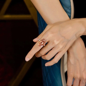 Elegant champagne oval gemstone ring in silver setting worn by a model on dark background