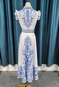 Detail of white sleeveless dress with paisley pattern, pleated trim and matching waist belt