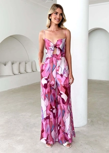 Front view of printed pink jumpsuit featuring a bow tie front and wide leg cut