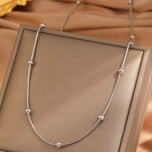 Polished silver stainless steel bead necklace displayed on a luxury jewelry box