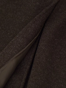 Close-up of deep brown wool fabric texture with smooth satin lining detail on the coat