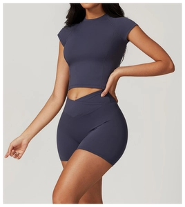 Dettaglio dell'elegante vita alta a V sui pantaloncini sportivi grigio scuro da donna