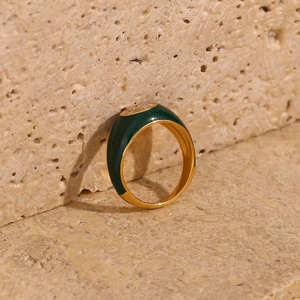 Detailed shot of 18K gold plated ring with green enamel and oval white zircon on stone