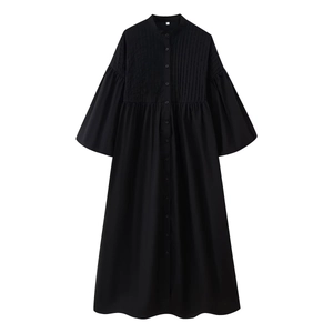 Black round neck dress with front buttons, pleated texture, and elegant puff sleeves