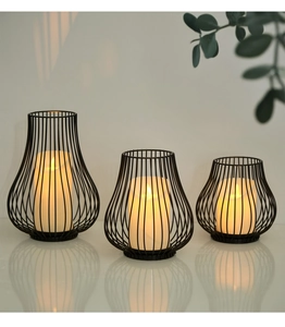Detailed view of three black iron frame candle holders with warm LED pillar candles