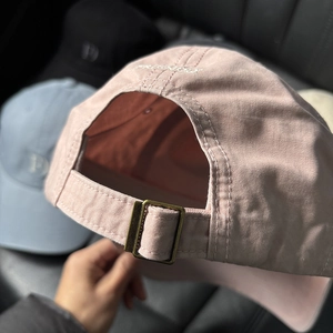 Close-up of pink cotton baseball cap with adjustable metal buckle and Friendly embroidery