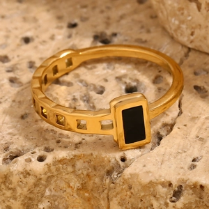 Macro detail of 18K gold plated ring with black enamel square and geometric hollow band