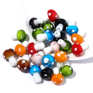 Close-up of colorful lampwork glass mushroom beads for DIY jewelry making with white dots