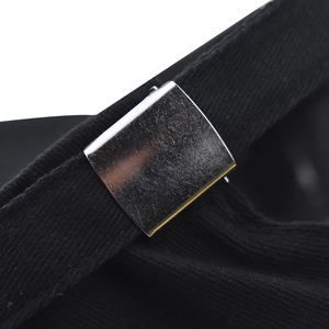 Macro detail of adjustable cotton baseball cap back strap with silver metal buckle