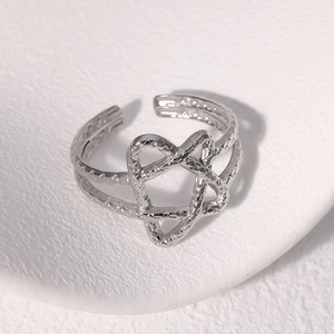 Detail shot of a silver adjustable star ring with layered geometric lines on white leather