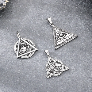 Detailed macro view of vintage stainless steel All-Seeing Eye and Masonic pendants