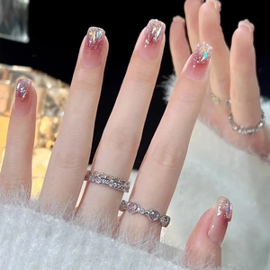 Pink gradient press-on nails with glitter accents and elegant silver rings