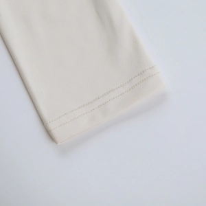 Détail de la couture double de haute qualité sur le haut de sport à manches longues crème