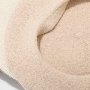 Close-up detail of high-quality wool felt fabric texture on beige beret hat