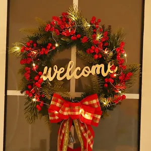 Christmas wreath with LED lights, red berries, Merry Christmas bow and Welcome sign