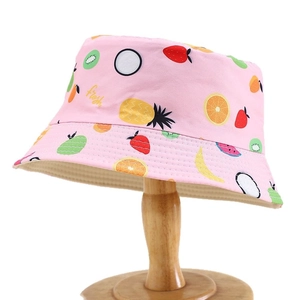 Pink kids summer bucket hat with fruit print and fresh lettering on wooden stand