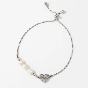 Detail of adjustable heart pendant pearl bracelet with slider clasp on white background