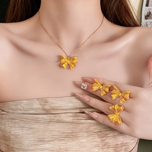 Detailed view of 18K gold-plated butterfly necklace and hollow rings on a model