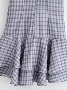 Dettaglio del tessuto vichy grigio e bianco con balze a strati sul vestito corto