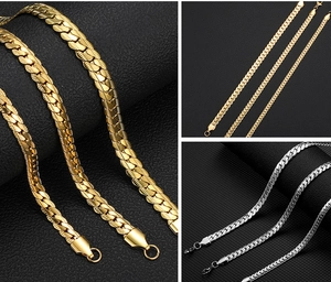 Macro view of polished gold and silver Cuban link chains in various widths on black background