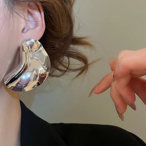 Macro detail of large silver irregular earrings with liquid metal mirror finish on model