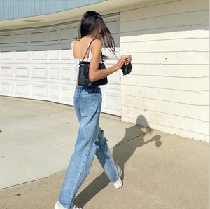 Women high waist push up distressed denim wide leg jeans shown from a side back view