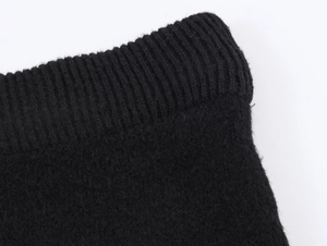 Detailed close-up of premium black knitted ribbing texture and fine fiber construction