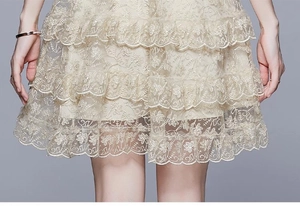Detail of multi-layered lace skirt featuring delicate embroidery and ruffle textures