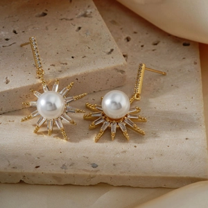 Elegant gold sunflower pearl earrings with zircon inlay on a beige stone and silk backdrop