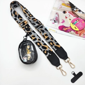 Detalle de correa de leopardo para teléfono con mosquetones dorados y bolsa pequeña de PVC
