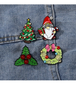 Detail of Christmas brooches with Santa and tree motifs pinned on blue denim fabric