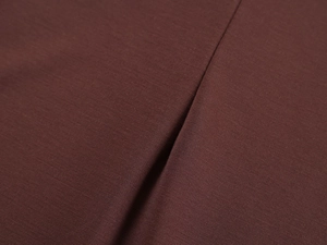 Close-up of reddish-brown knit fabric showing high-quality texture and soft fiber details