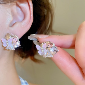 Detail showing crystal butterfly stud earrings with pink pearls and 18k gold plating