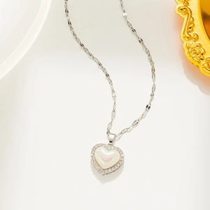 Detailed view of silver heart necklace featuring a mother-of-pearl center and sparkling rhinestones