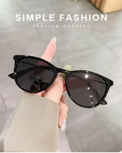 Detail of oval sunglasses with black frame and dark grey lenses for children