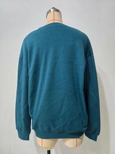 Rückansicht eines lockeren Rundhals-Sweatshirts mit tiefen Schultern und Bündchen in Blaugrün