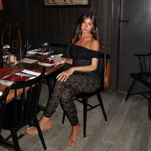 Detailed view of black floral lace texture on an off-shoulder elegant bodysuit