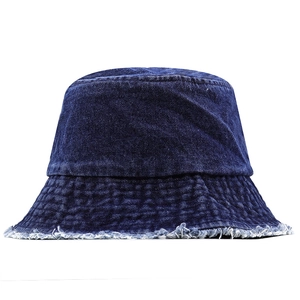 Détail d'un bob en jean bleu foncé avec des bords effilochés et des coutures de qualité