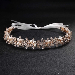 Détail du bandeau de mariée avec fleurs dorées, perles nacrées et cristaux brillants