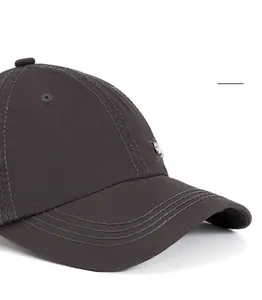 Detail of reinforced stitching on the curved brim and metal label of the cotton baseball cap